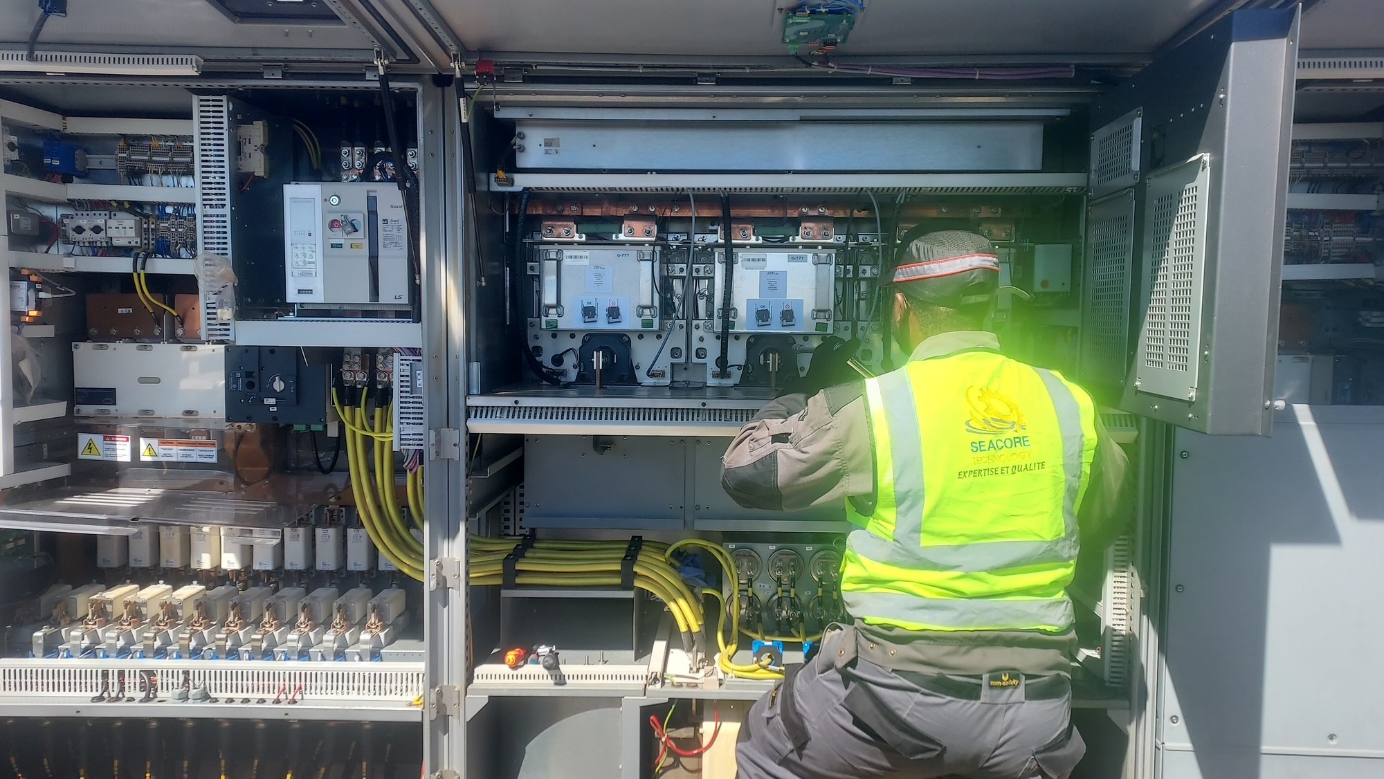 Electrician in soft hat working on a pannel